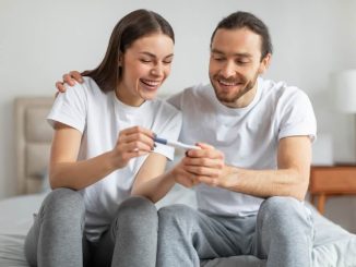 זוג שמח מחזיק בדיקת הריון