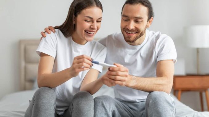 זוג שמח מחזיק בדיקת הריון